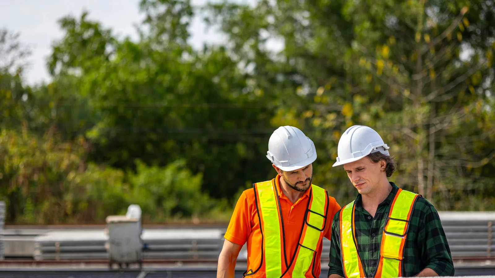 Two construction professionals reviewing project information outdoors