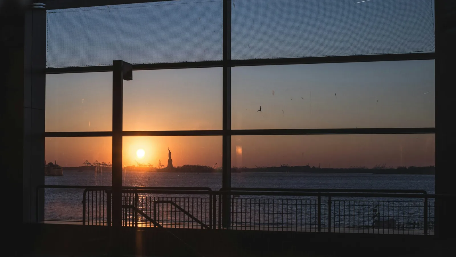 Low sunlight shining through a grid of glass panels overlooking a waterfront